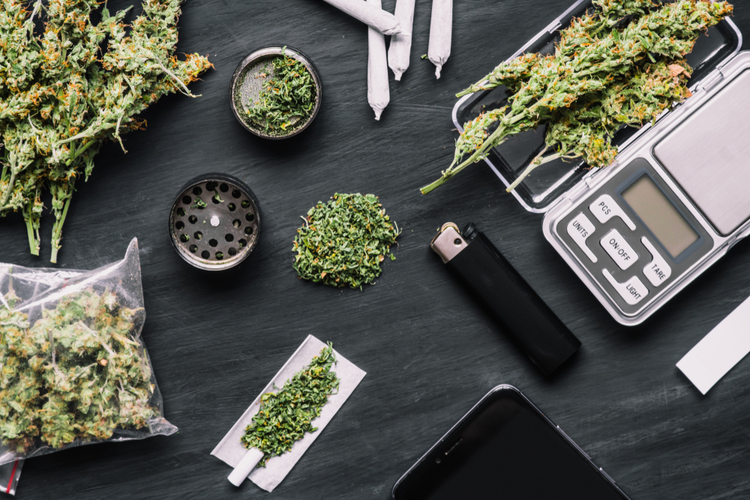 CBD flowers, a crusher, lighter, scale and CBD joints, which are options for taking CBD flowers