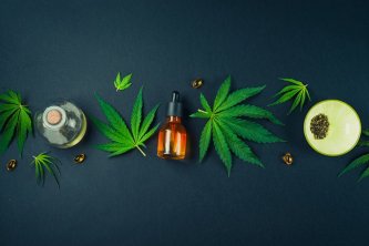 Medicínsky olej CBD na čiernom modernom pozadí s konopnými listami. Koncept lekárskej tinktúry z marihuany.