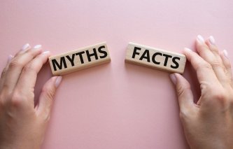 Símbolo de Hechos o Mitos. El concepto de la palabra Hechos o Mitos en bloques de madera sobre fondo rosa.