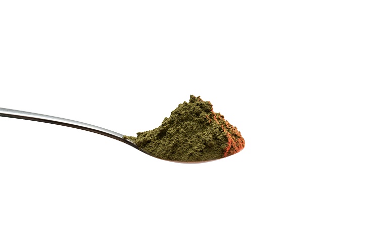 A teaspoon full of green kratom powder, with dosage always being an individual matter